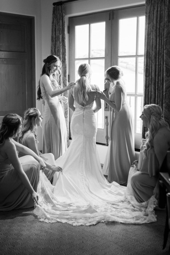 Bride surrounded by bridesmaids looking out the window