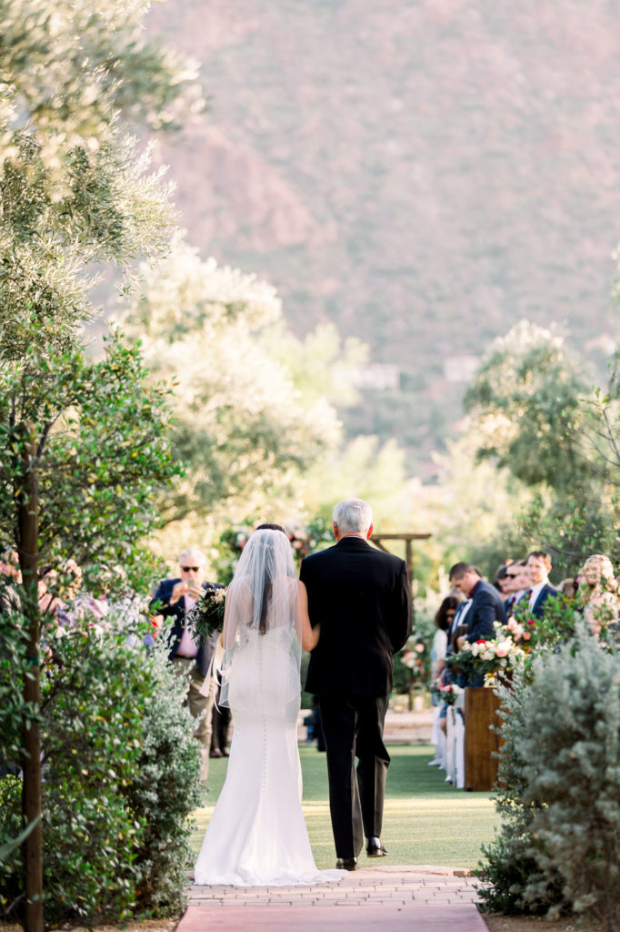 Father waling his daughter down the aisle photographed from behind with the montain in the background at El Chorro weddings