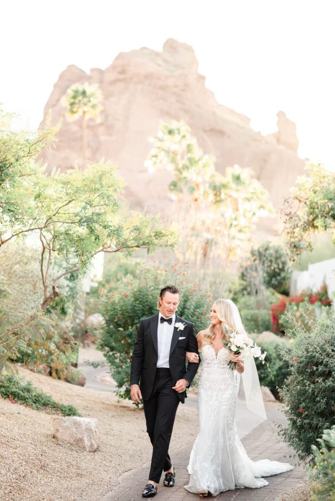 Bride and Groom walking down a path with Camelback mountain in the backgroud at the Sanctuary Wedding Venue
