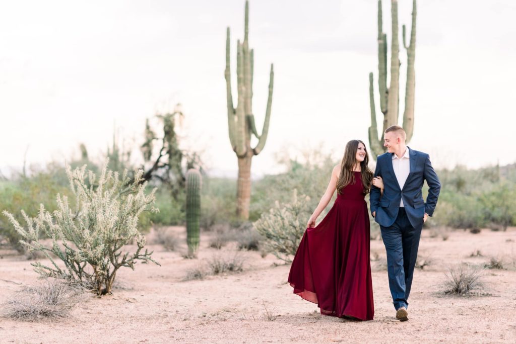 A couple walking in the Tonto National Forrest with large cacti.