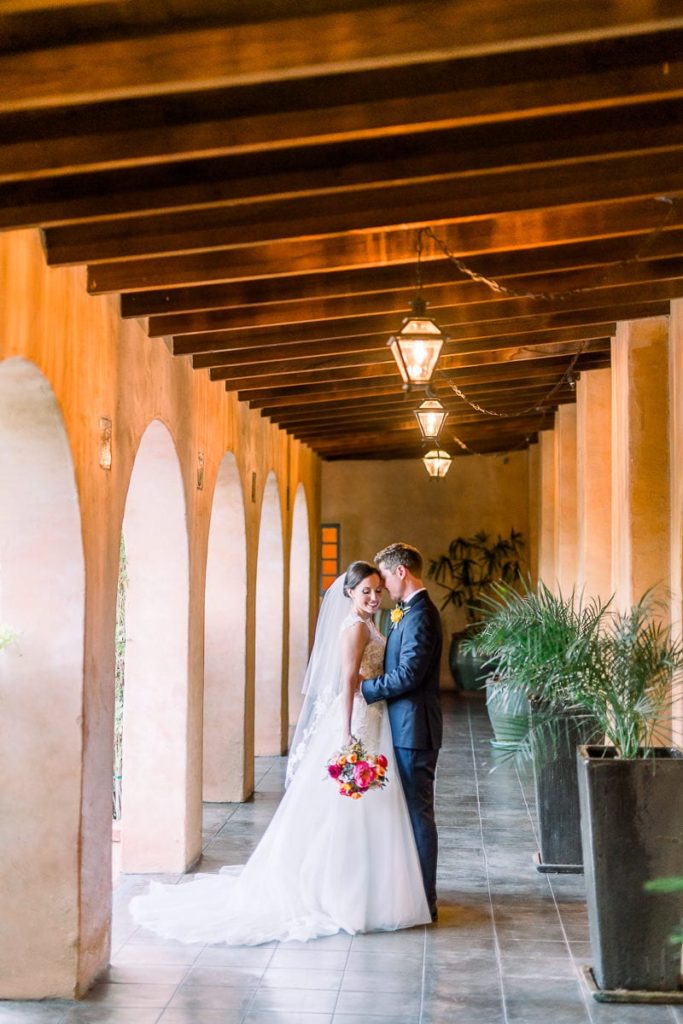 Groom holding bride close in the hallway at Royal Palms wedding venue