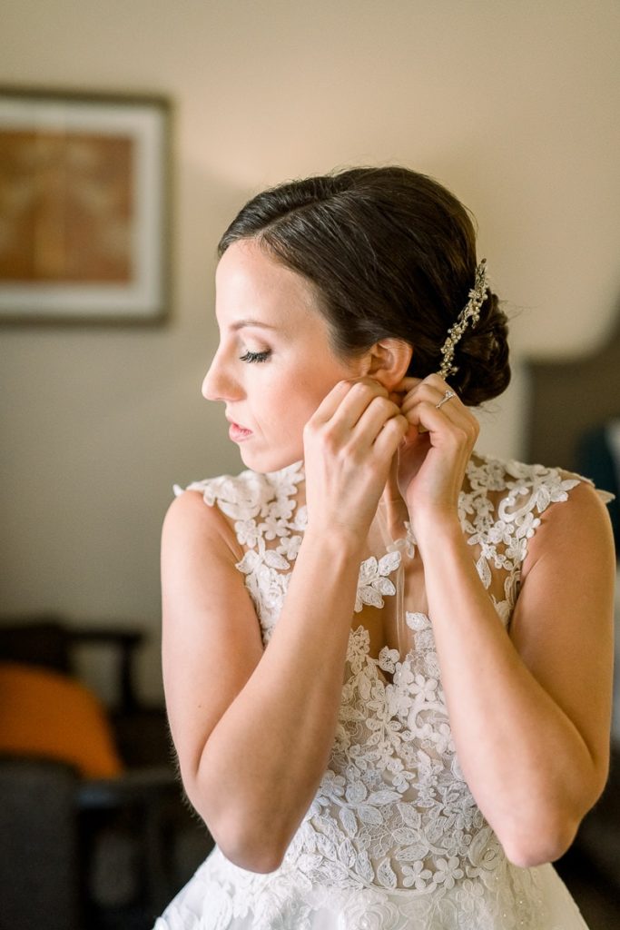 bride putting on her jewelry 