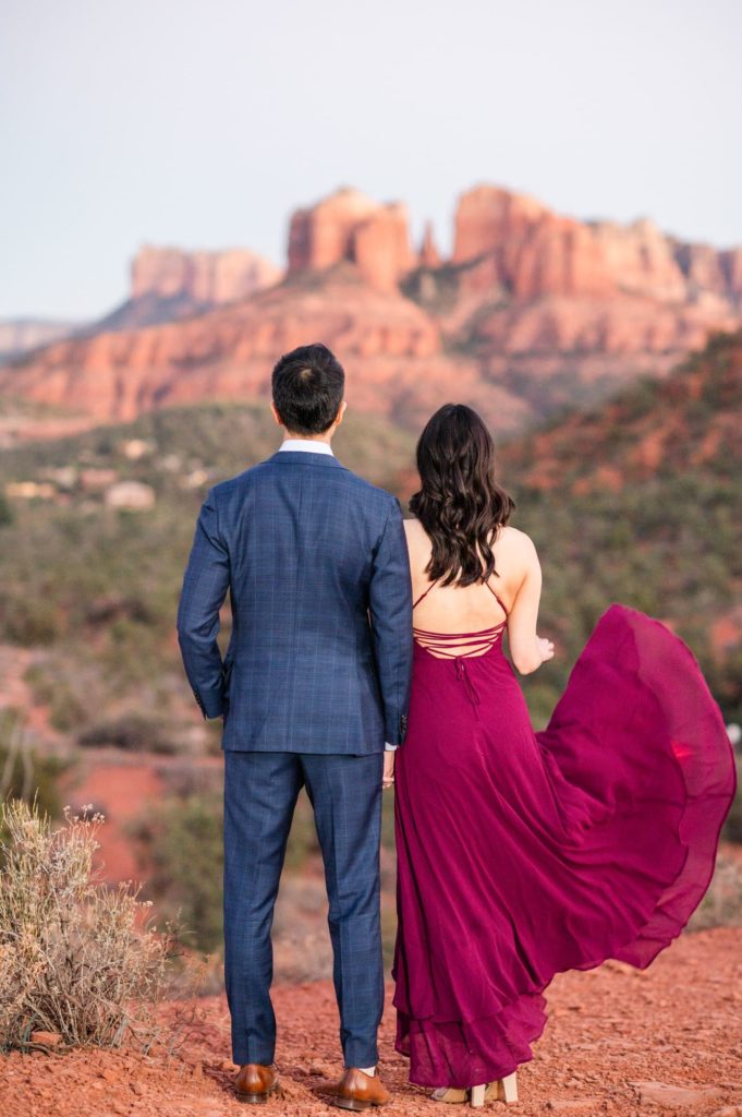 Couple facing mountain views during engagement session in Sedona