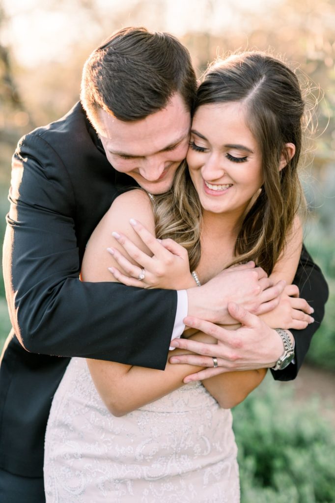 Groom holding bride tight laughing