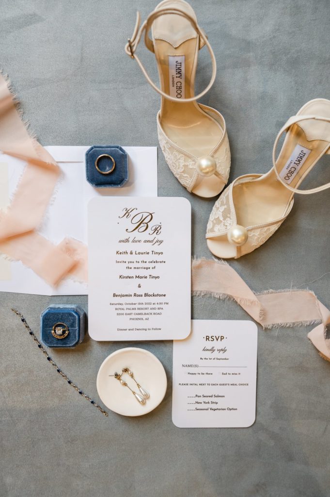 Wedding flat lay with invitation suite, shoes, and rings