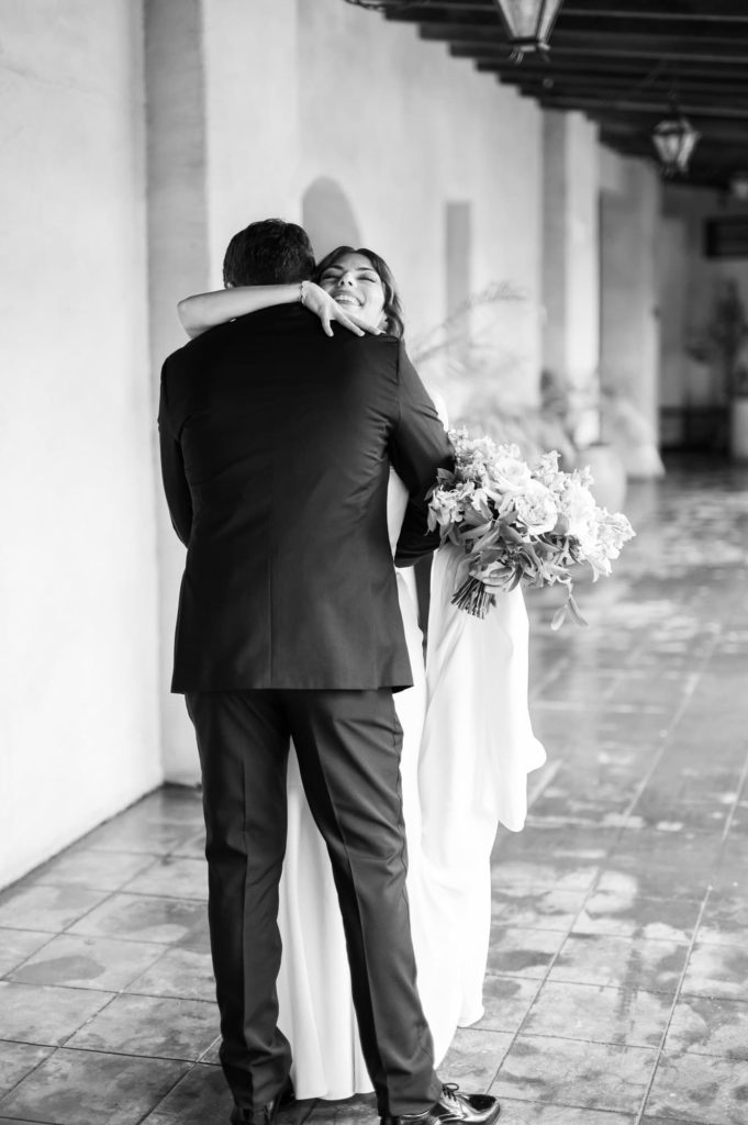 Bride and Groom hug after first look in black and white