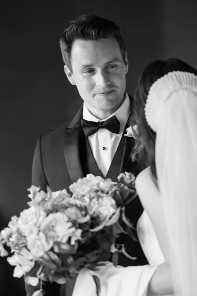 Groom looking at bride smiling in black and white