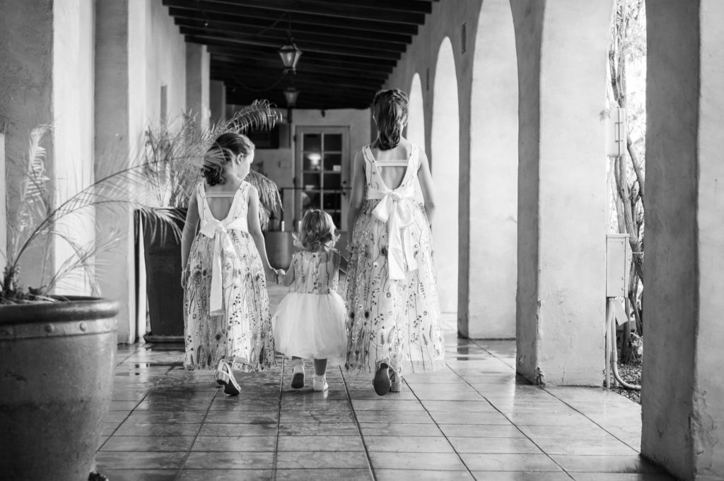 A Royal Palms Resort Wedding with three little flower girls walking down the hallway