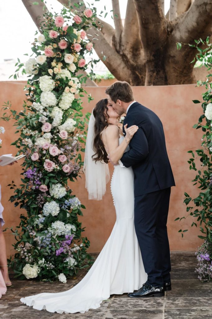 Groom kissing bride at alter for first kiss at Royal Palms