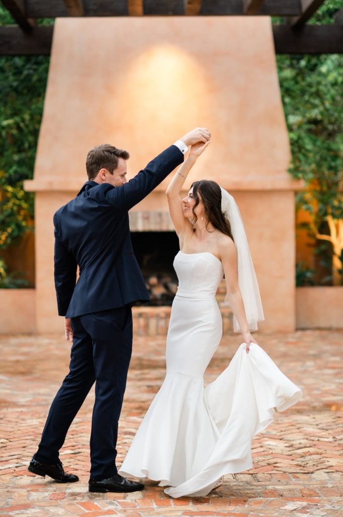 Bride and Groom dancing in front of the outside fireplace