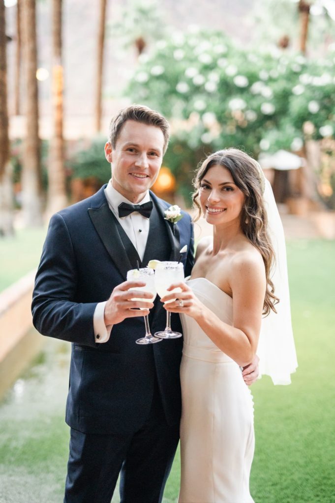 Bride and Groom holding drinks smiling while close together at Royal Palms