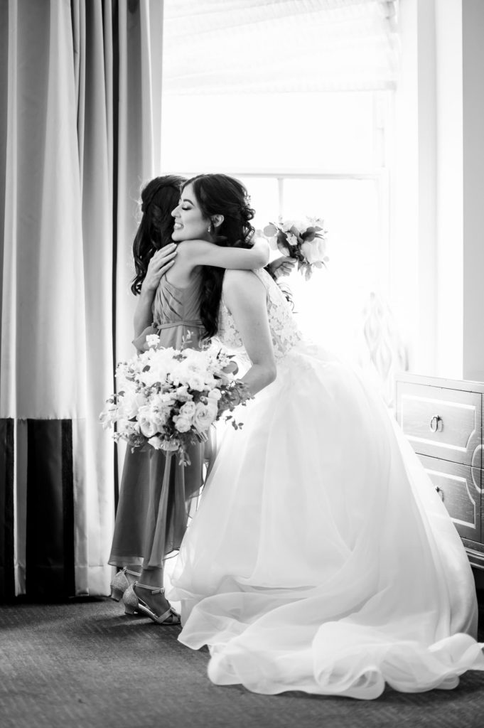 Mayflower Hotel DC Wedding showing the bride hugging daughter inside the getting ready room in front of large window
