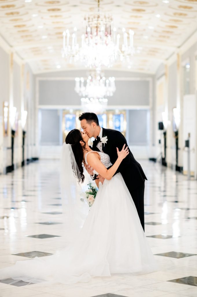 Bride and Groom kissing in the Grand Hallway during their wedding at The Mayflower Hotel DC