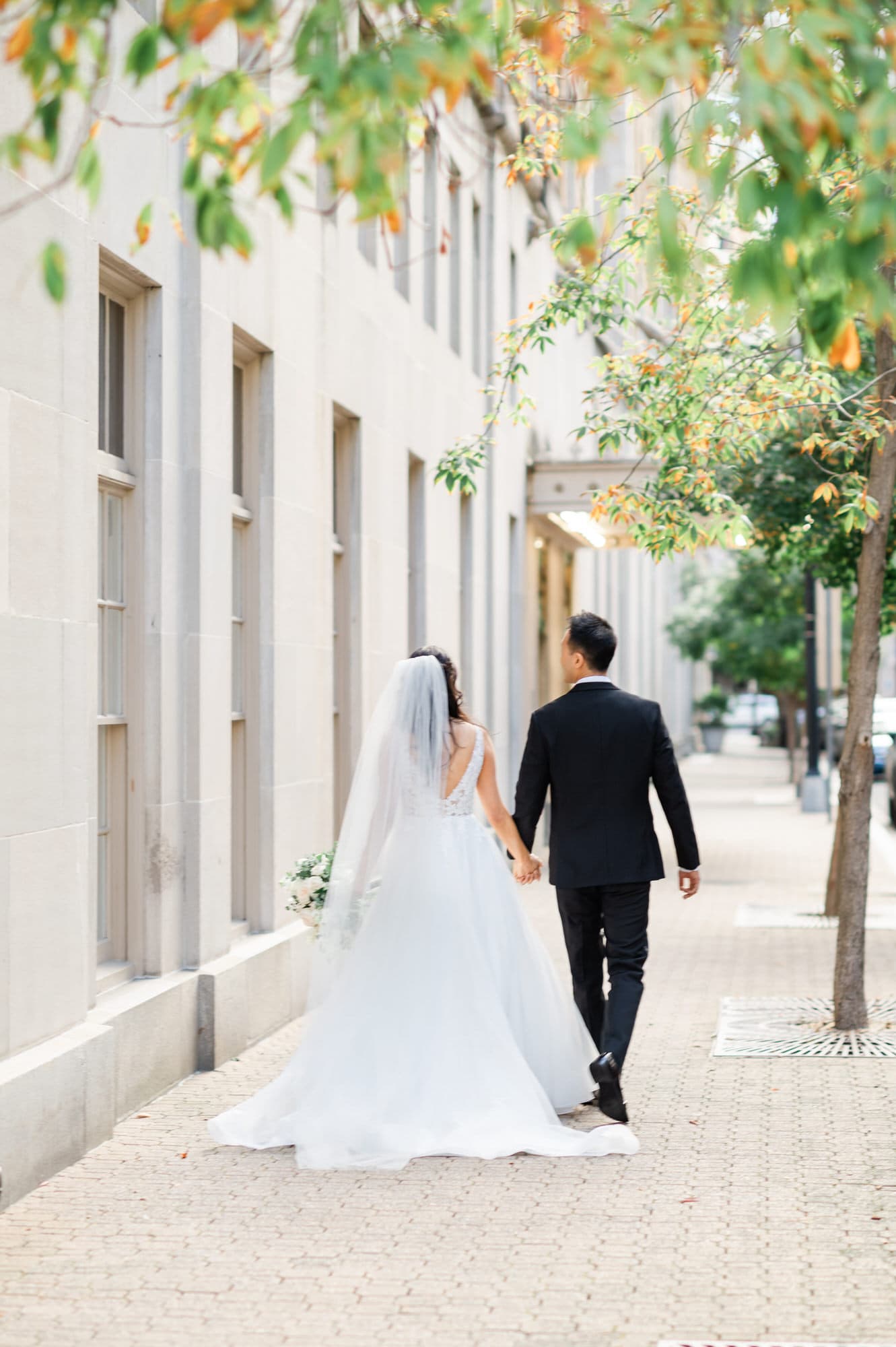 Bride and Groom holding hands walking down the sidewalk outside the Mayflower Hotel DC Wedding venue