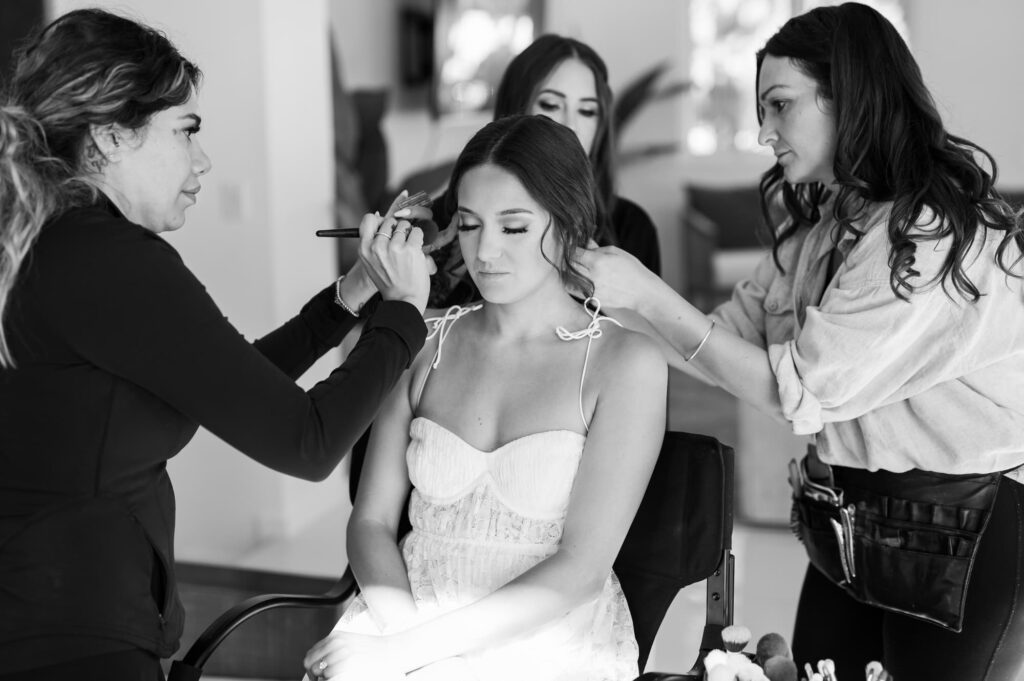 Bride sitting having hair and makeup done at same time