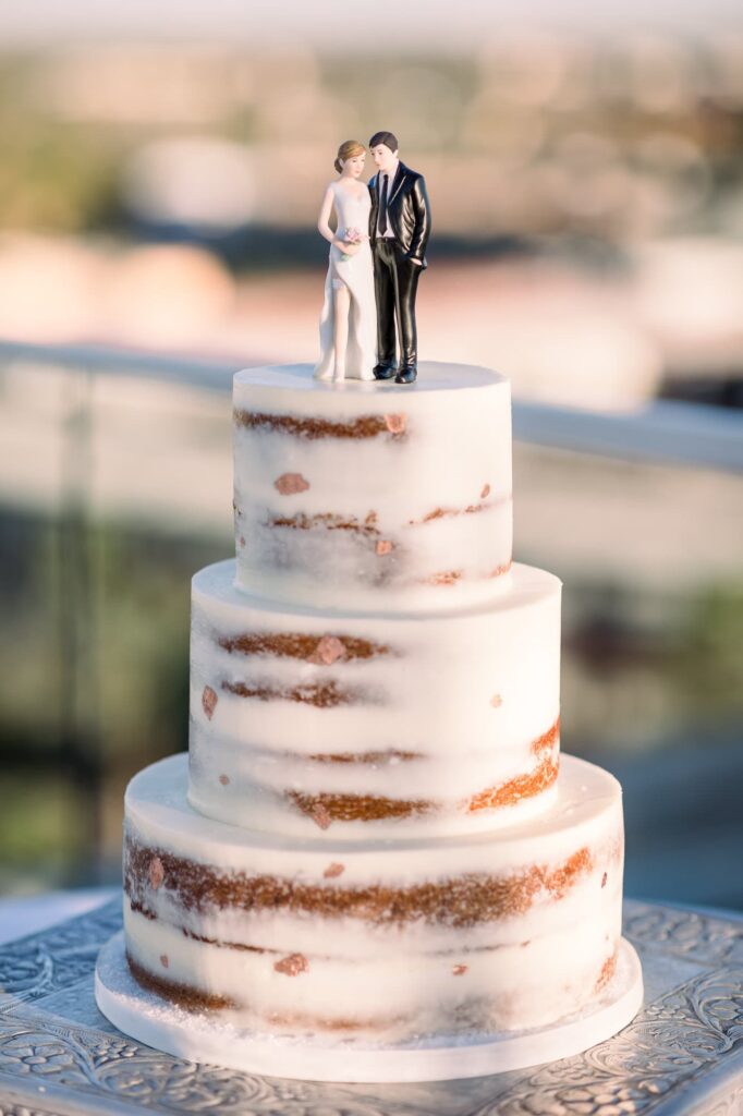 Wedding cake with bride and groom figures on top.