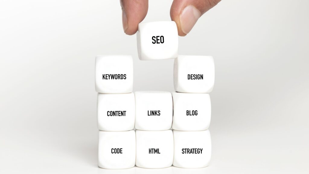 stacking dice with SEO words listed on each. Keywords, SEO, Design, Links and more are listed.